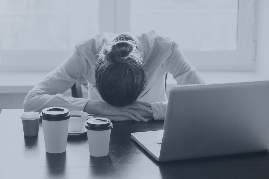 Frau mit Kopf auf der Tischplatte Burnout