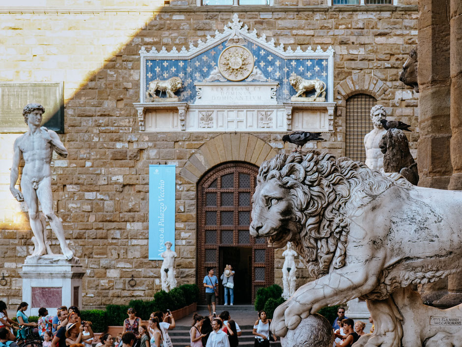 One of Medici's lions in the foreground - Entrance of Palazzo Vecchio in the background