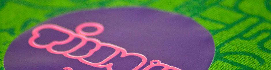 Nahaufnahme eines Plott-Transfers auf grünem Stoff mit violettem Kreis und rosafarbener Schrift.