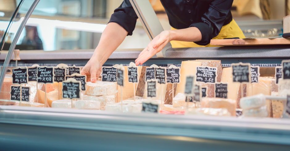Symbolfoto: Ein Mitarbeiterin zeigt Ware in einer Supermarkttheke