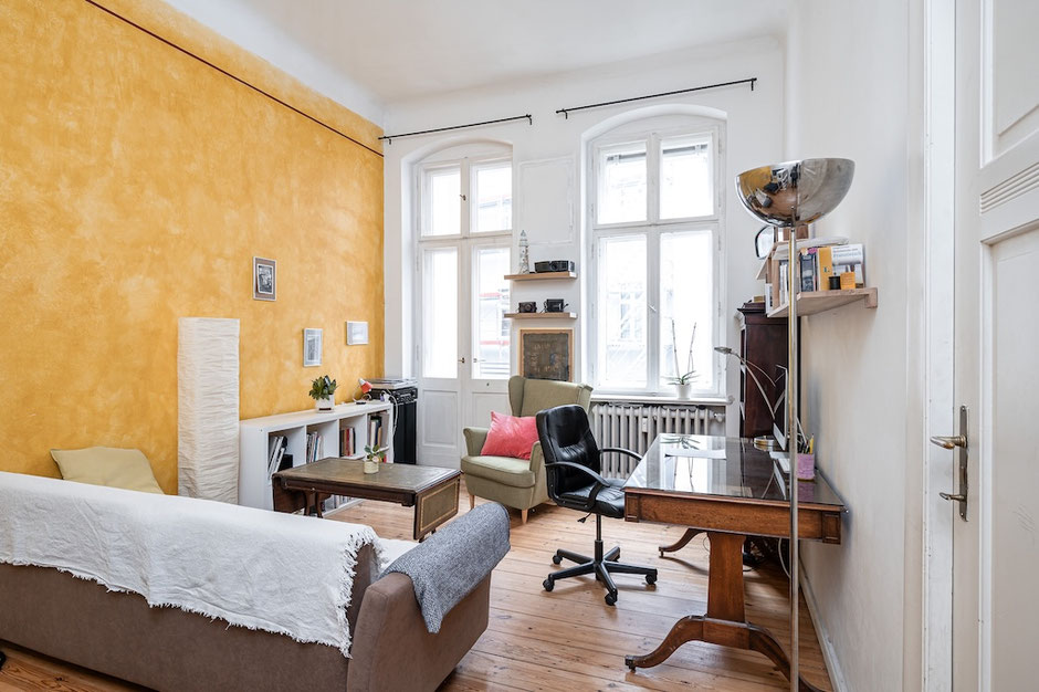 Wohnzimmer einer bezugsfreien Altbauwohnung in Berlin-Tempelhof mit Dielenboden und Stuckdecke