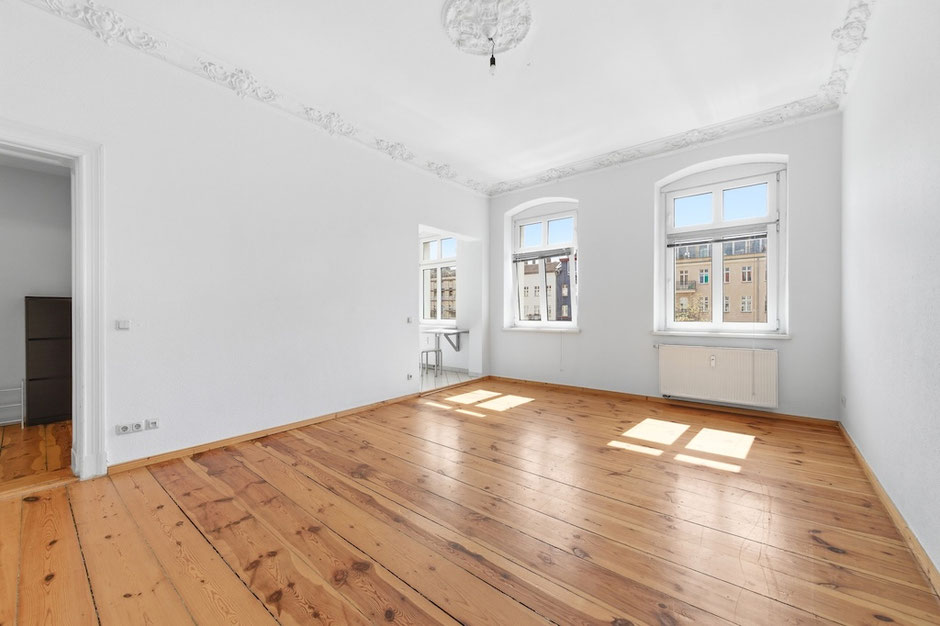 Wohn- und Schlafbereich der bezugsfreien 1-Zimmer-Altbauwohnung mit Dielenboden und hohen Decken