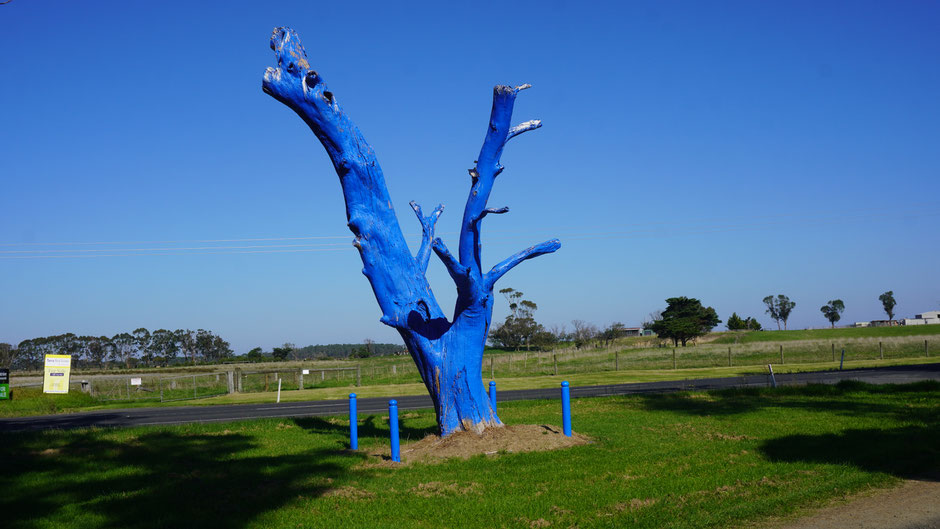 Blaue Baumskulptur im Grünen