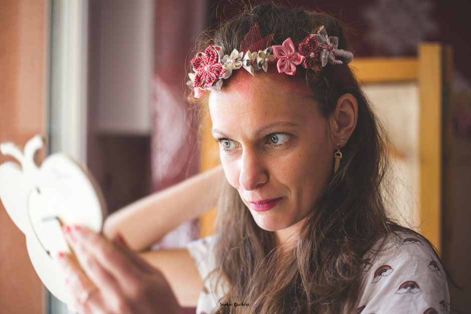 Confection artisanale d'une couronne de fleurs en tissus et papiers pour un mariage thème Japon en rose, rouge et blanc par La mariée en fleur. Crédit photo: Sophie Bachère