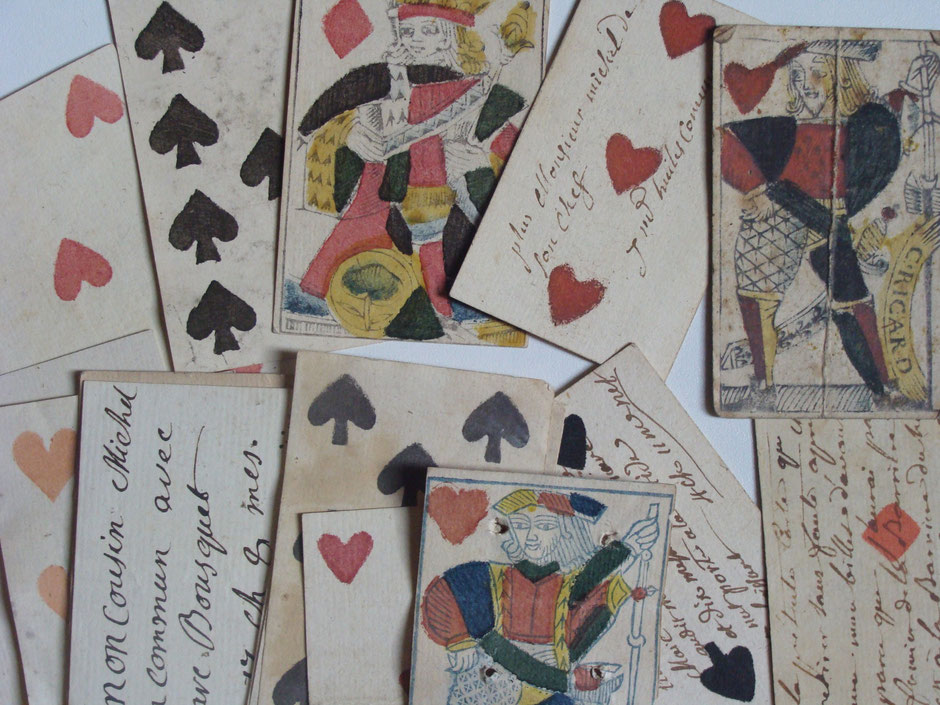 Cartes à jouer du XVIIIe siècle jointes à des liasses d'archives et portant des annotations. (archives JGD)
