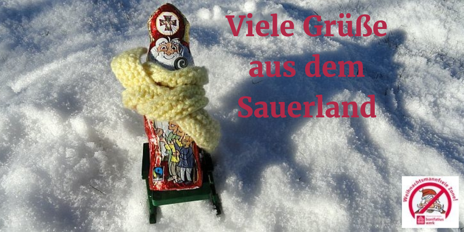 Mit einem dicken gelben Schal sitzt der Nikolaus auf einem Liegestuhl im Schnee.