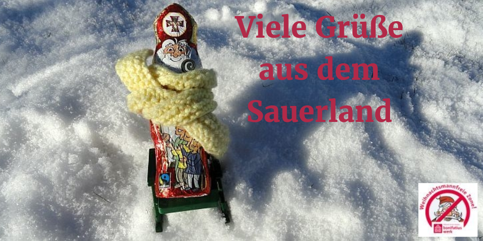 Mit einem dicken gelben Schal sitzt der Nikolaus auf einem Liegestuhl im Schnee. 