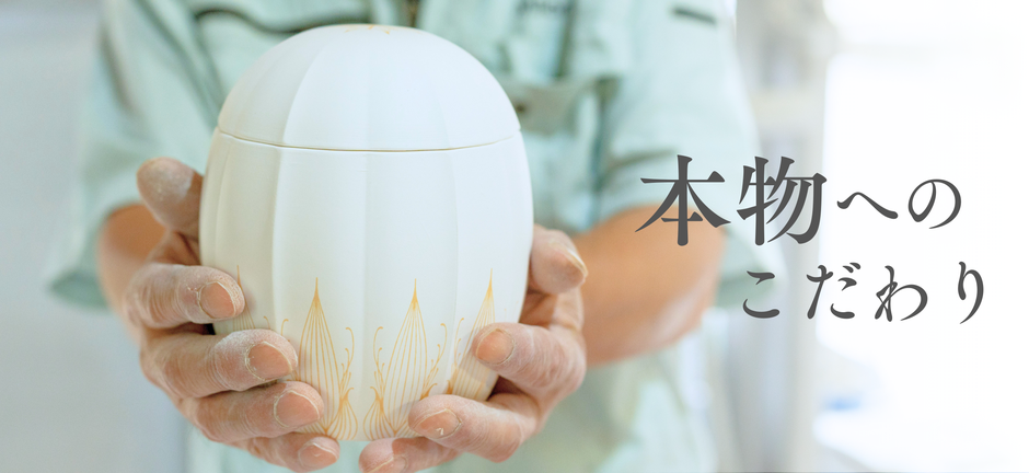 職人が両手ではなつぼみを包み込むように持っている様子。