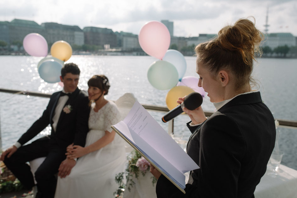 Hochzeitsrednerin Constanze mit Brautpaar auf einem Boot. Alle sind festlich gekleidet. An der Reling sind bunte Luftballons