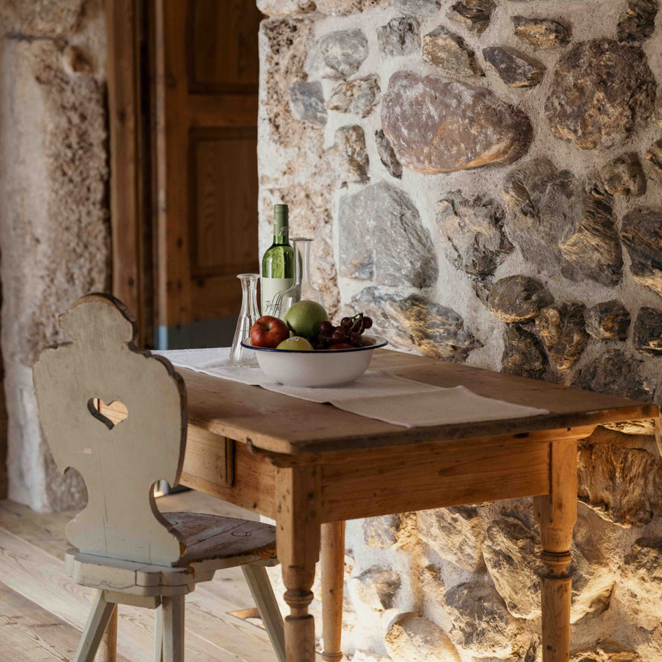 Speiseraum mit historischen Steinmauern und ladinischen Gerichten in der Ciasa Somuer • Member of Mountain Hideaways ©MarikaUnterladstätter