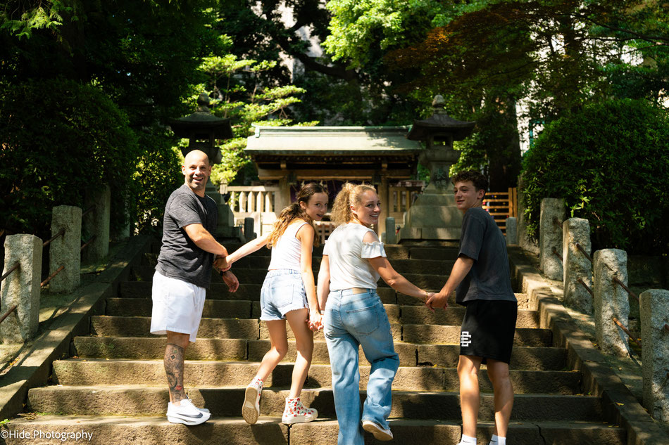 Family walking up stone steps at Nezu Shrine during a peaceful morning photoshoot in Tokyo