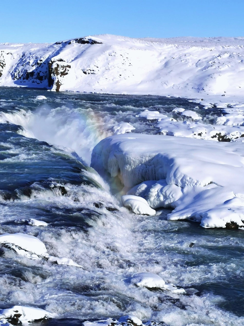kleiner Regenbogen durch Wasserfall Urriðafoss