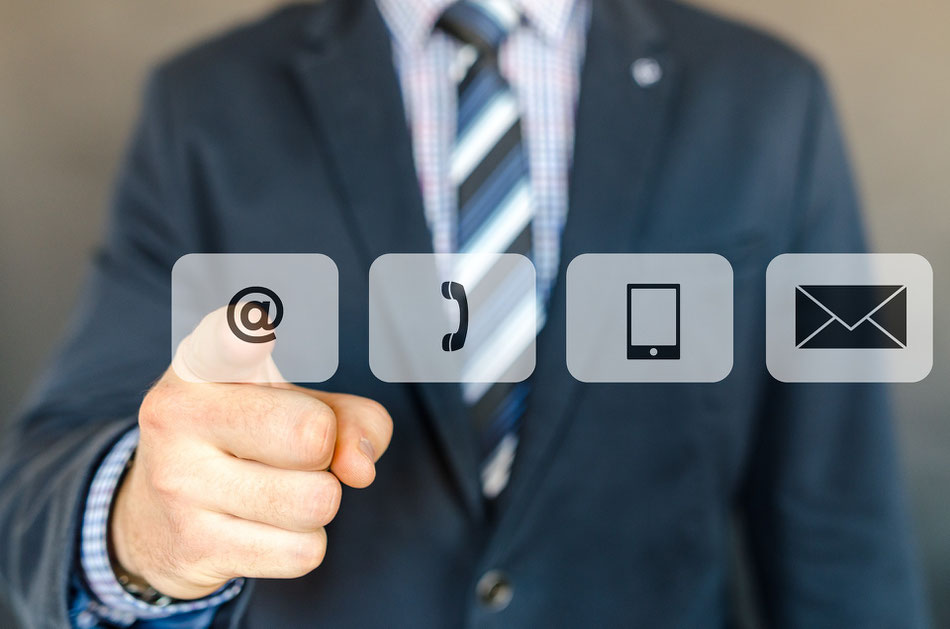 Ein Bild eines Mannes, der verschiedene Icons (wie ein Mail Symbol) vor sich hat. Das Bild soll die verschiedenen Kontaktmöglichkeiten symbolisieren.