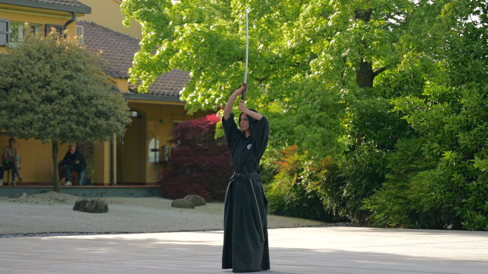 Praticante di ai jutsu che sta eseguendo una tecnica con la katana