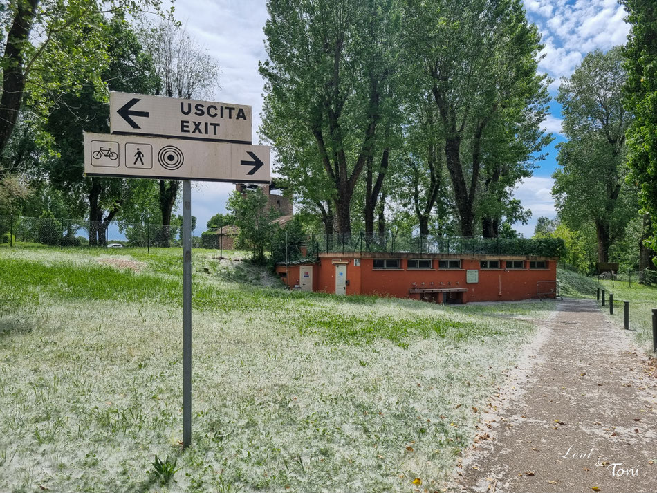 Der Fußweg ins historische Zentrum ist über einen Park erreichbar. Im Hintergrund das etwas mitgenommene Sanitärgebäude.