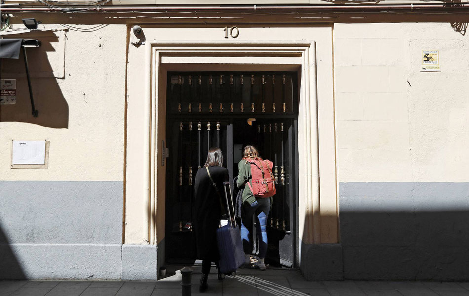 Dos personas entran a un piso de alquiler turístico, en la calle de Encomienda 10, en Madrid. LUIS SEVILLANO