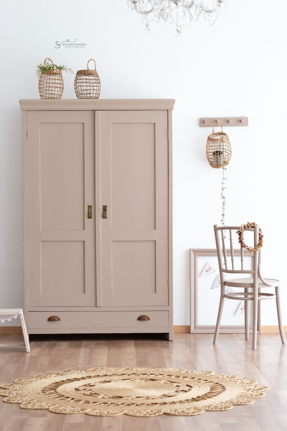 Antiker Holzschrank mit zwei Türen und einer Schublade, der Schrank ist in Lachsrosa gestrichen. 