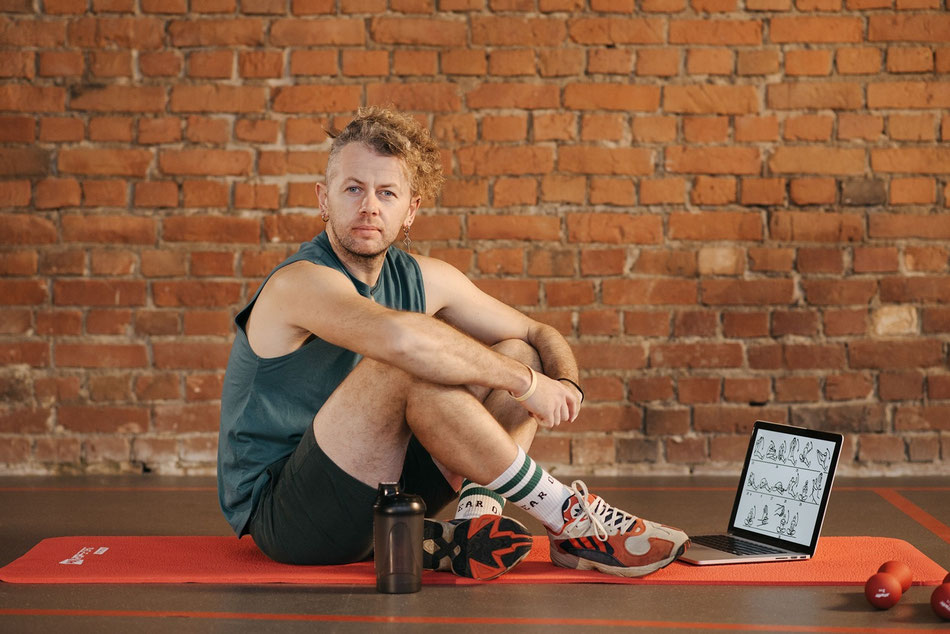 Mann absolviert ein Online-Beckenbodentraining zuhause.