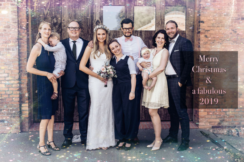 Hochzeitsrednerin Constanze mit drei Paaren vor großer Holztür, eingelassen in Wand aus rotem Backstein