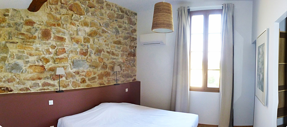 La chambre lie-de-vin, qui donne sur le patio et au loin les contreforts de la montagne noire : lit king size 180x200