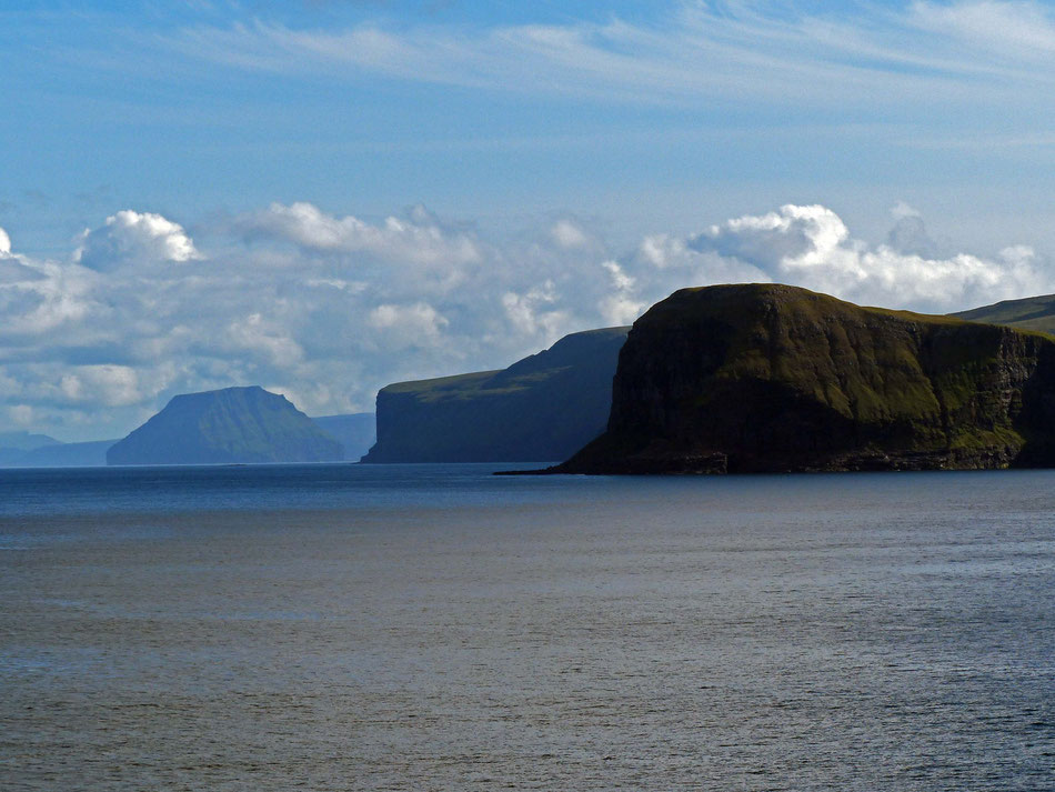 Auch steile Klippen gehören zum Bild der Färöer - im Hintergrund links die Insel Lítla Dímun. Sie ist die kleinste und als einzige ständig von Menschen unbewohnte Insel der Färöer - Papageientaucher und Schafe fühlen sich hier aber pudelwohl.