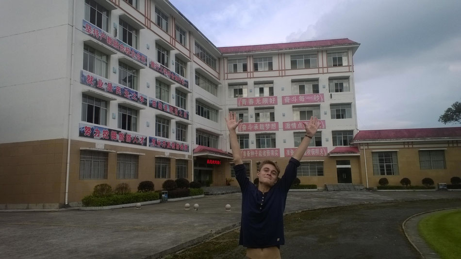 Der Reiseführer läd zum Rundgang – Lukas vor der Berufsschule in Xiaping