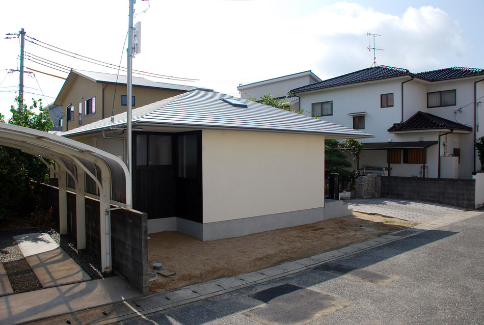 道路側からの眺め。十字形平面に方形屋根が乗った形となっている。