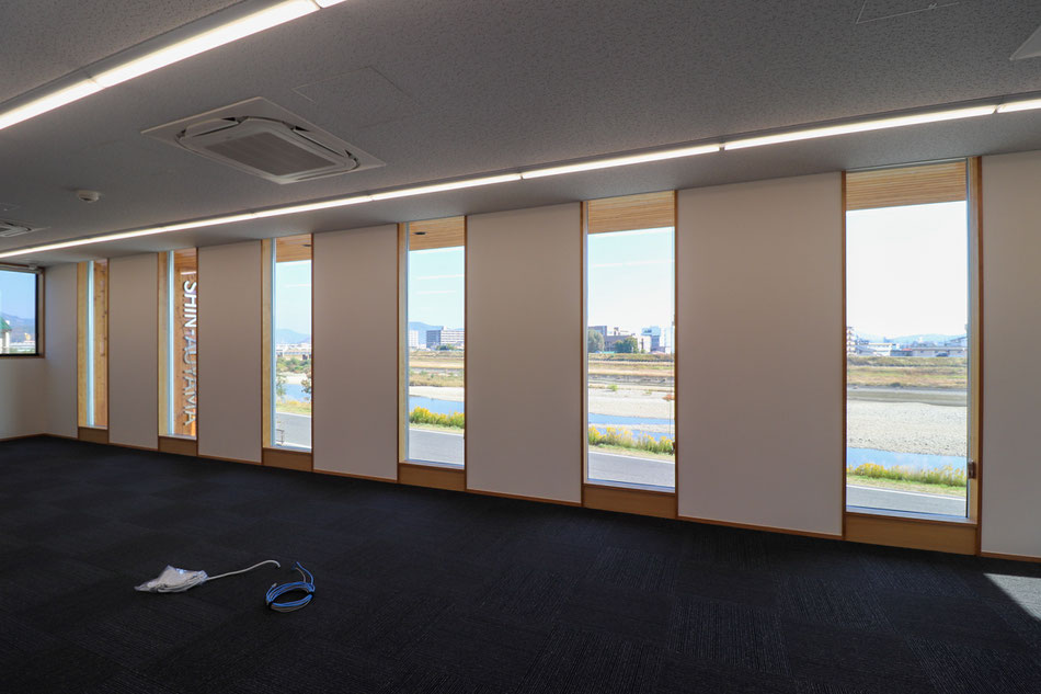 規則的に配列する耐力壁の先には、川の風景が連続している。