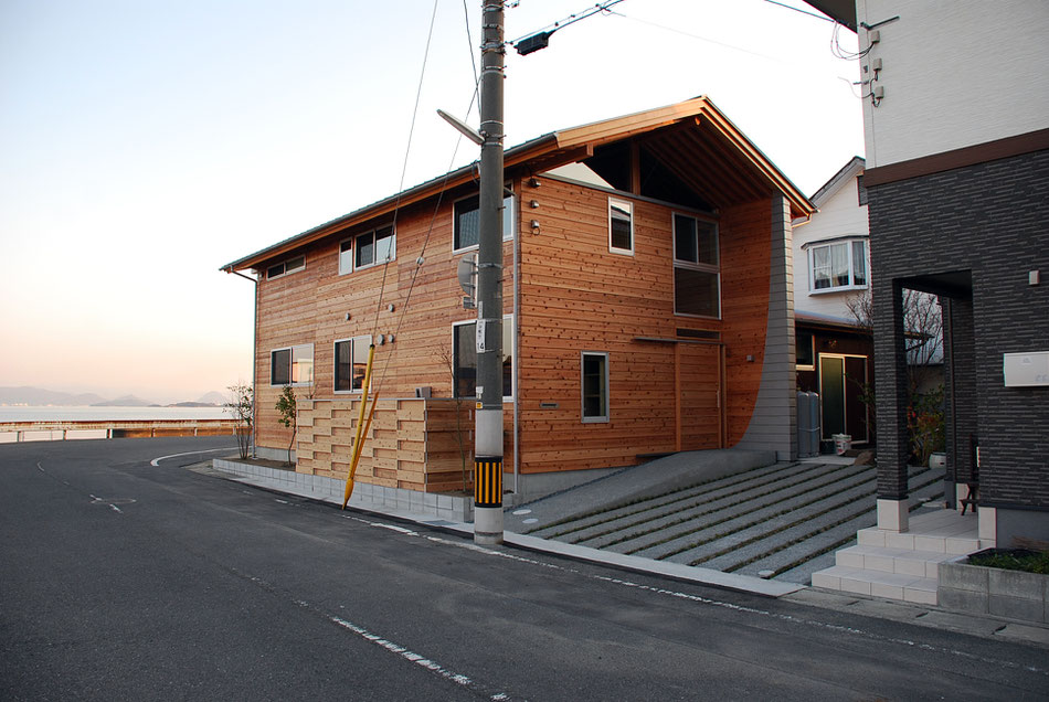 海側ファサード。大きな開口部が並び、どの部屋からも海の絶景を望むことができるようにしている。  2階右端は海を望む浴室となっている。