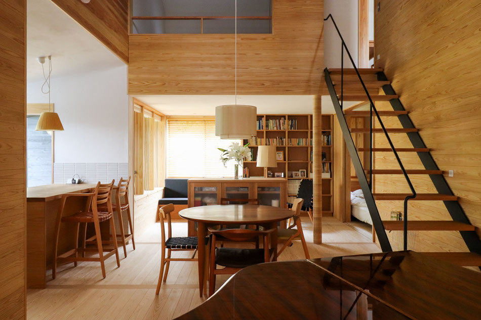 吹抜のダイニングの先には、天井高さを抑えたリビングが続いている。ほぼ全ての部屋がダイニングの吹抜に面している。