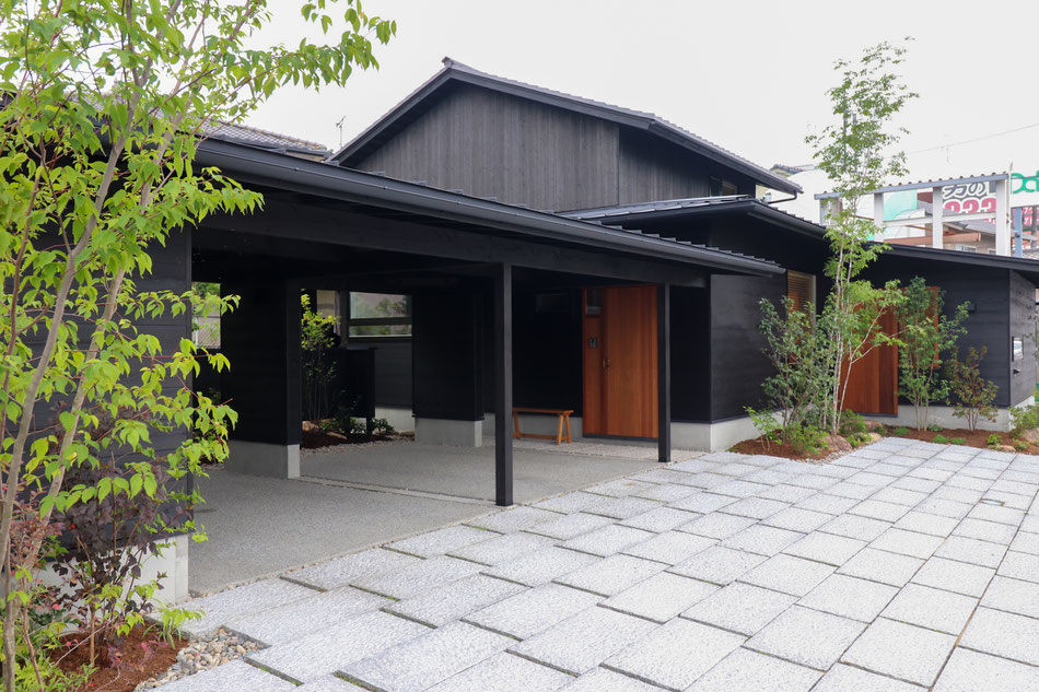 玄関へのアプローチ。3層の屋根が重なりあうように続いている。近年の豪雨や日射に対応し玄関前に大きな屋根を架けている。