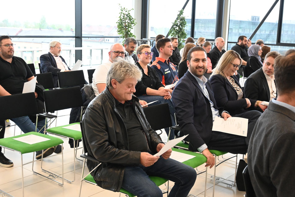 Gäste sitzen im Veranstaltungsraum und warten auf den Beginn