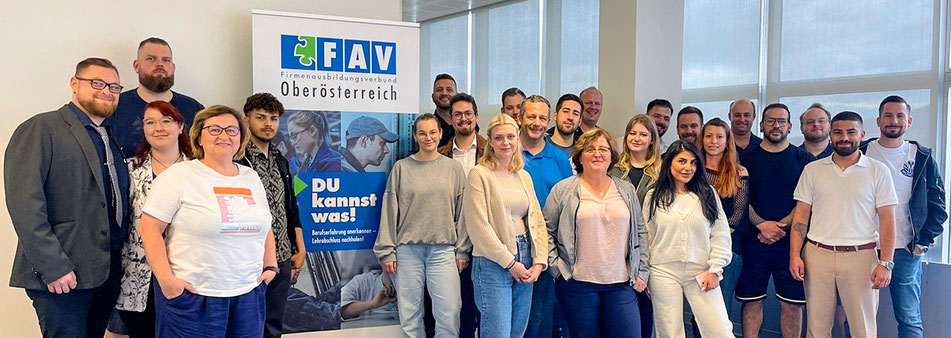 Absolvent:innen vor FAV-Rollup nach Lehrabschluss in Bahnreise- und Mobilitätsservice
