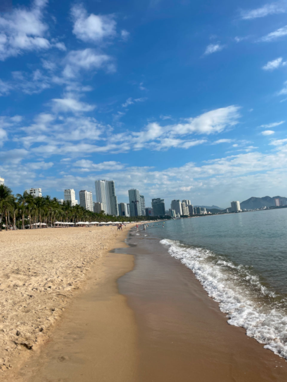 Blick auf den Strand von Nha Trang mit Hochhäusern im Hintergrund