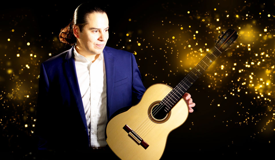 Alejandro Carrillo Gamboa mit Gitarre vor Lichtpunkten