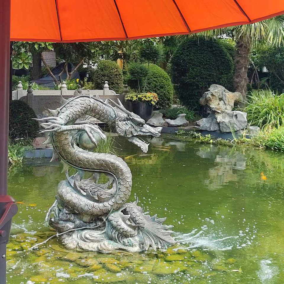 Auf dem Dach ist der Drache Zierrat. Im Teich ist er an seinem Platz.