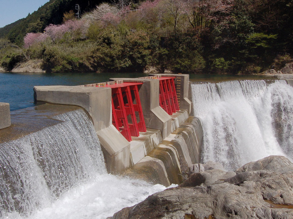 赤い堰堤の左右からの越流も迫力。写真奥の岸上をR257が通っている
