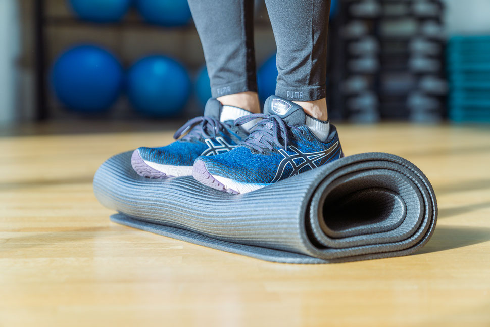 Antara Übung stehend mit Schuhen auf gerollter Matte für Balance