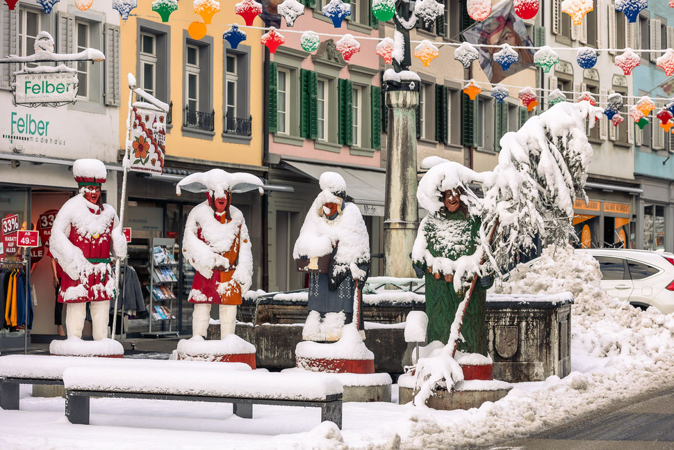 Skuril verschneite, überlebensgrosse Holz-Brauchtumsfiguren der Karnöffelzunft vor dem Rathaus
