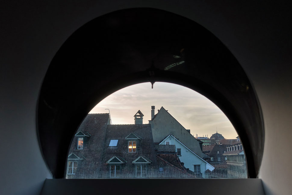 The image shows the photograph of roofs in the old town of Bern shot through a semi circle skylight.  