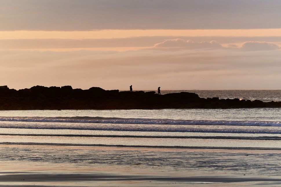 The image shows the photograph of a coastal landscape at dusk. The location is Pointe de la Torche near Plomeur (Brittany).
