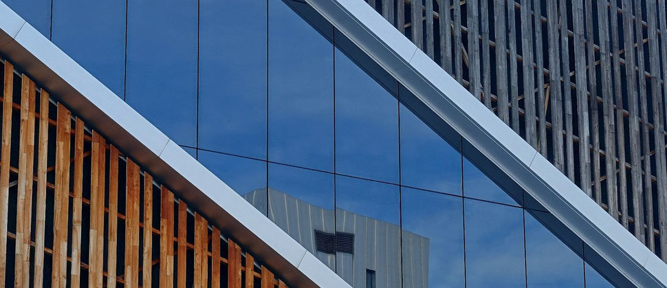 The photograph shows an image of a snippet of the facade of the Westside Shopping Center. Part of the facade consists of a  window that reflects the opposite building.