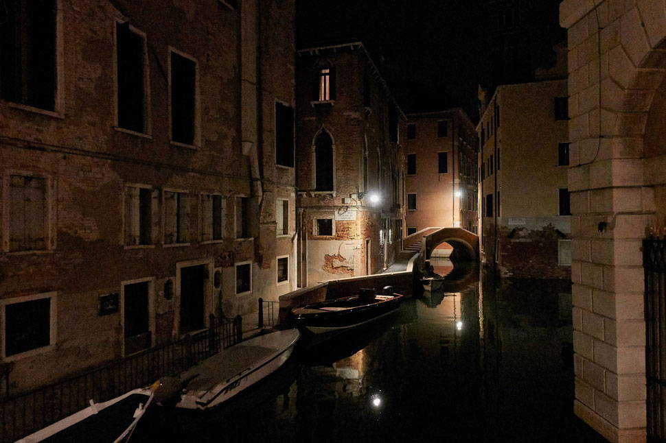 The image shows a photograph of empty passages and canals in Venice by night.