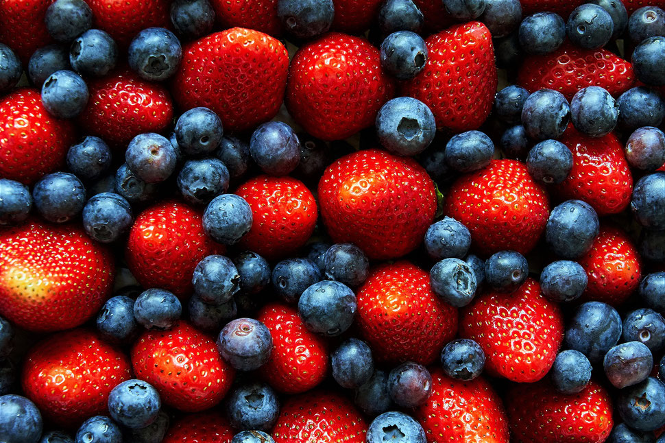 The image shows a closeup photograph of a mix of strawberrys and blueberrys.