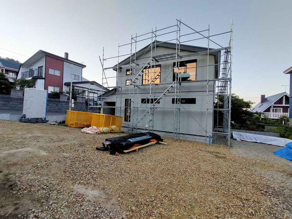 足場が組まれた建物外観。塗装下地サイディングの施工が完了している。