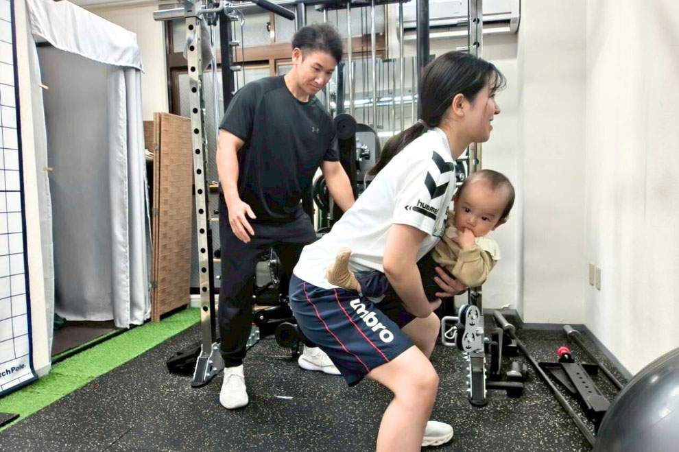 赤ちゃんを抱っこしながらスクワットするママ。産後ダイエットに取り組める府中のパーソナルジム健想