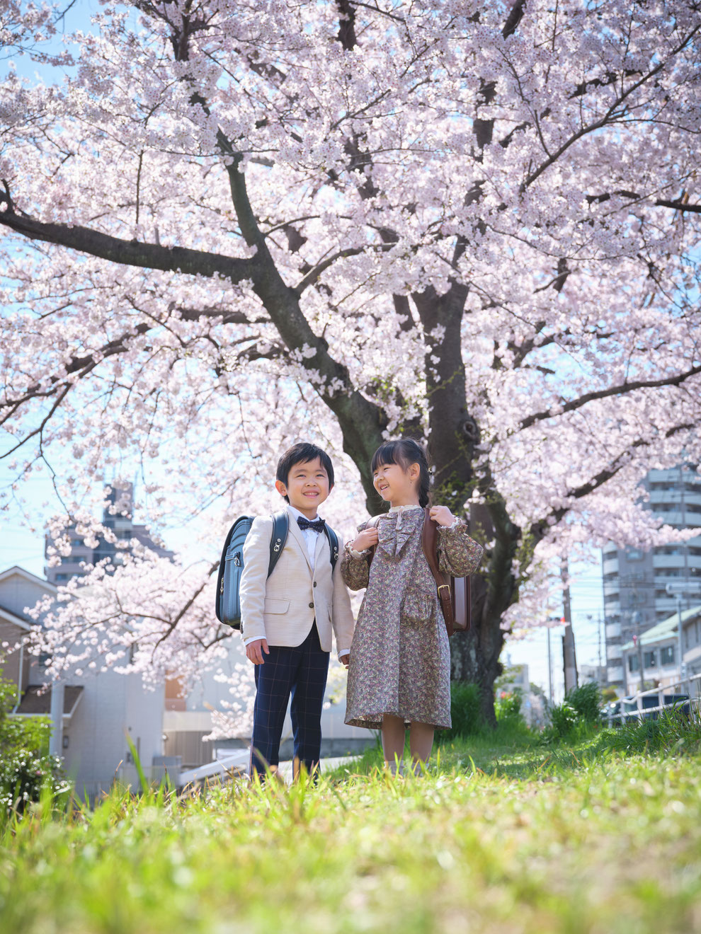 桜の前でランドセルをかついだ入学記念写真