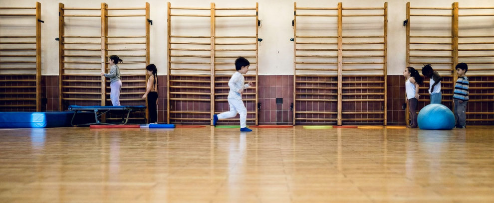 Kinder der Kita Rotkäppchen machen in einer Turnhalle Sport