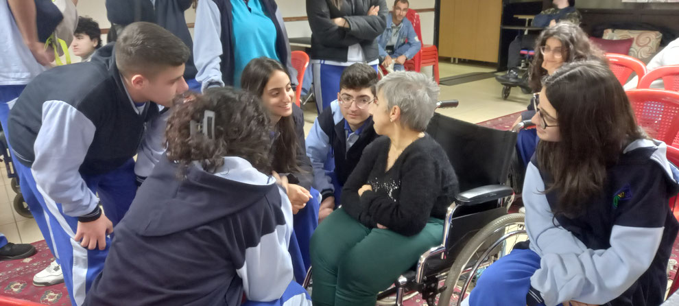 Femme handicapée en fauteuil roulant et élèves sensibilisées