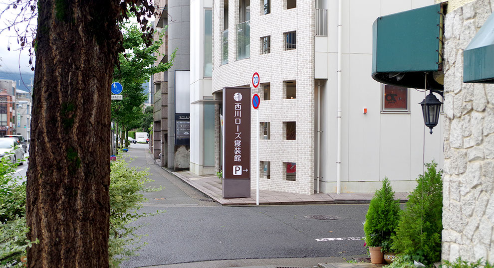 会社概要のイメージ写真　お店の前にある西川ローズ寝装館の看板